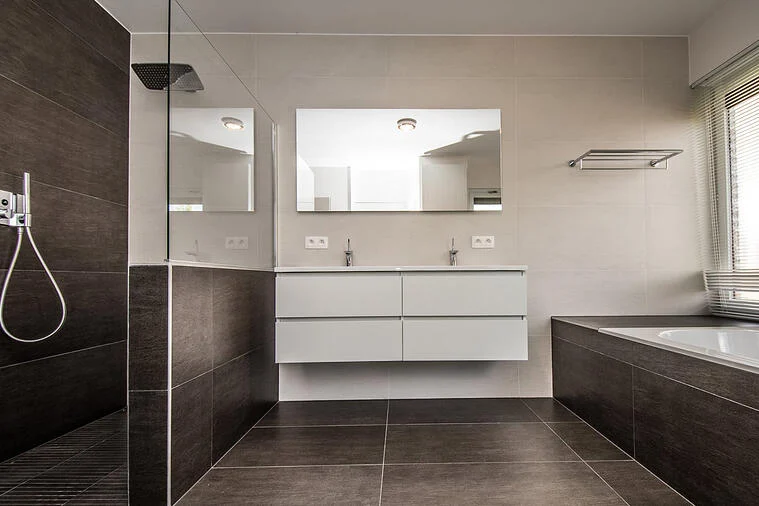 Badkamer met lavabo meubel en zwarte tegels